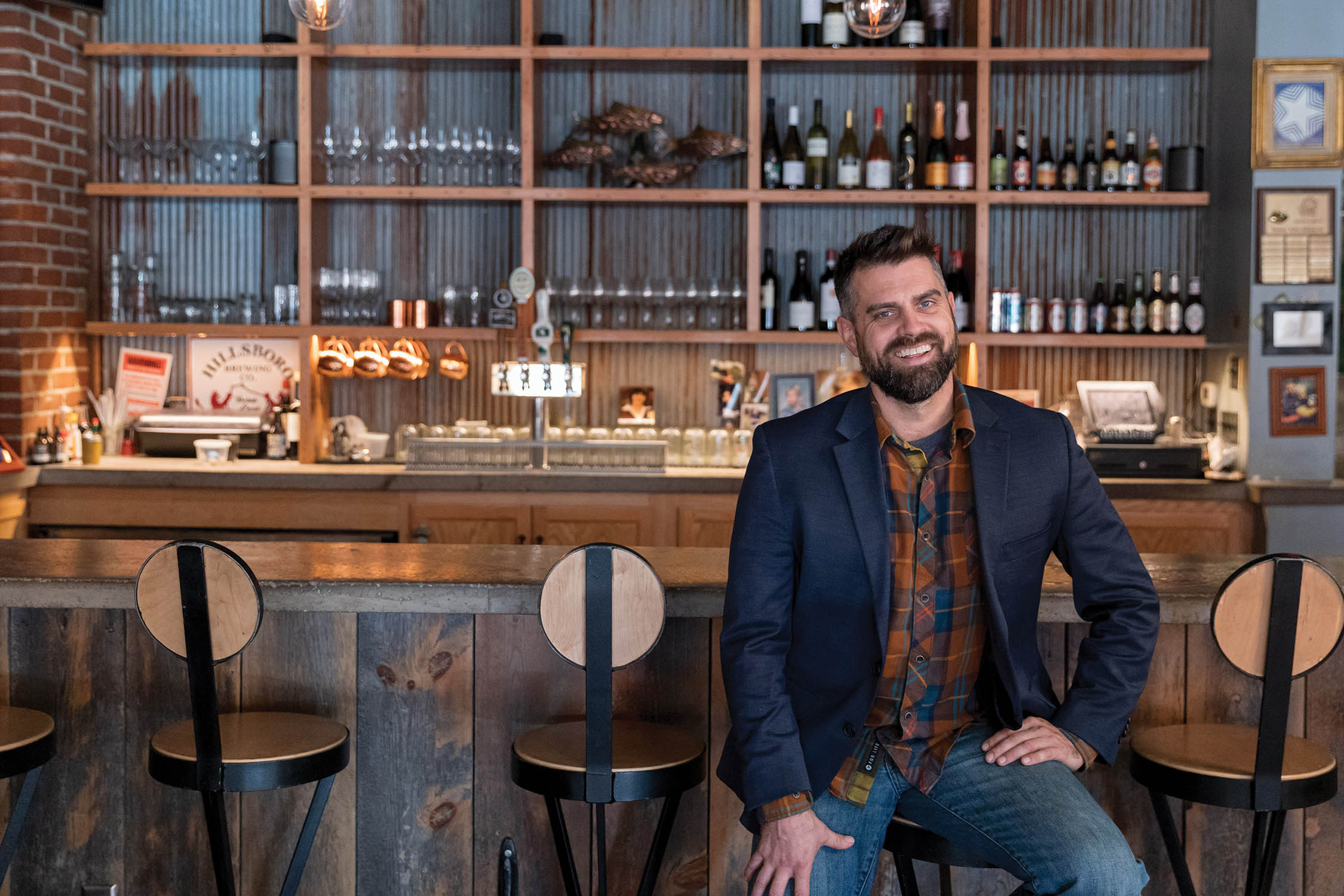 Luke Zahm sits at the bar in his restaurant, Driftless Cafe.