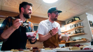 Luke Zahm smiles as he tastes a dish at his restaurant