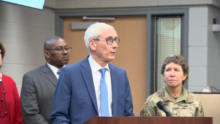 Tony Evers - Governor of Wisconsin stands at a podium at a press conference Tony Evers - Governor of Wisconsin stands at a podium at a press conference