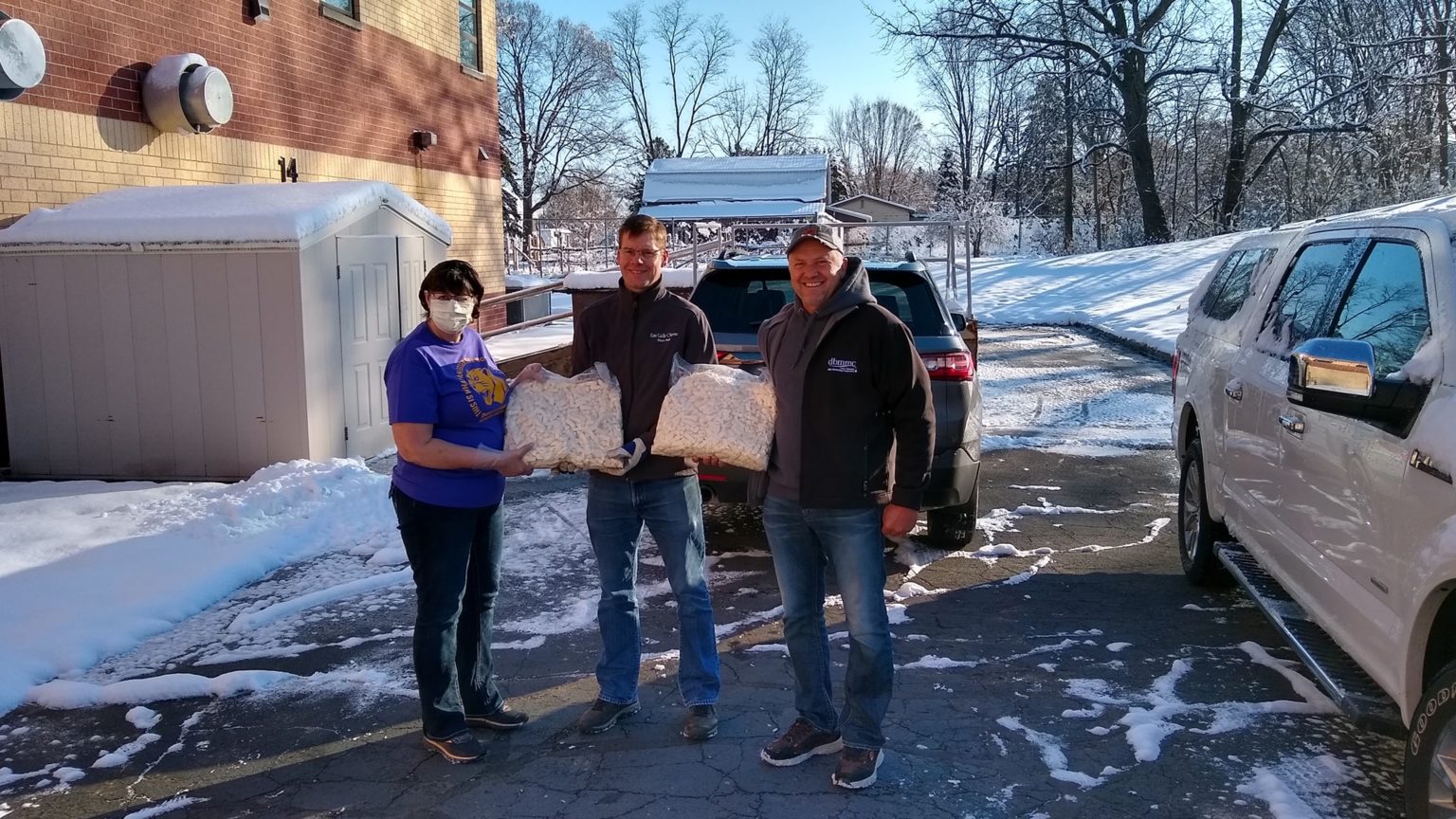 Cindy Reinhardt from the Durand Arkansaw School District accepts a donation from Steve Bechel of Eau Galle Cheese Factory and Don Weiss from Weiss Family Farms. (Courtesy: Brian Winnekins)