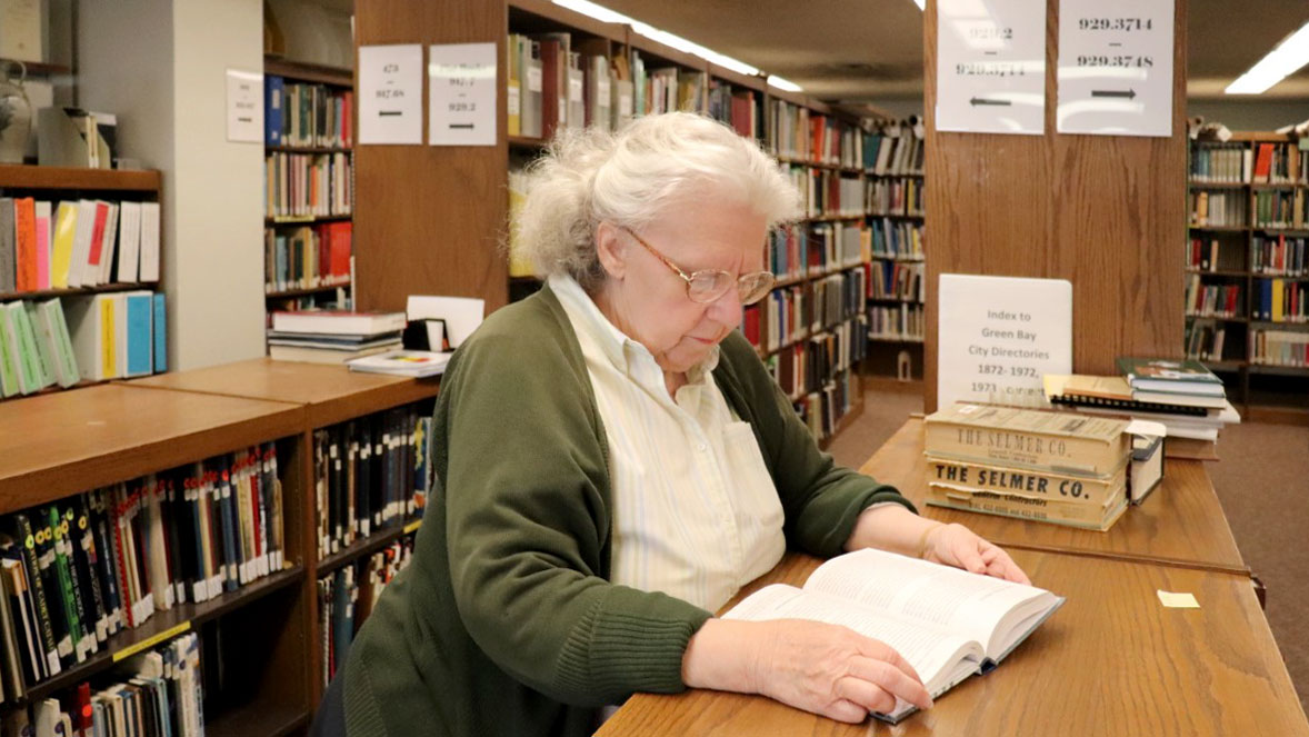 Woman reading a book in a library