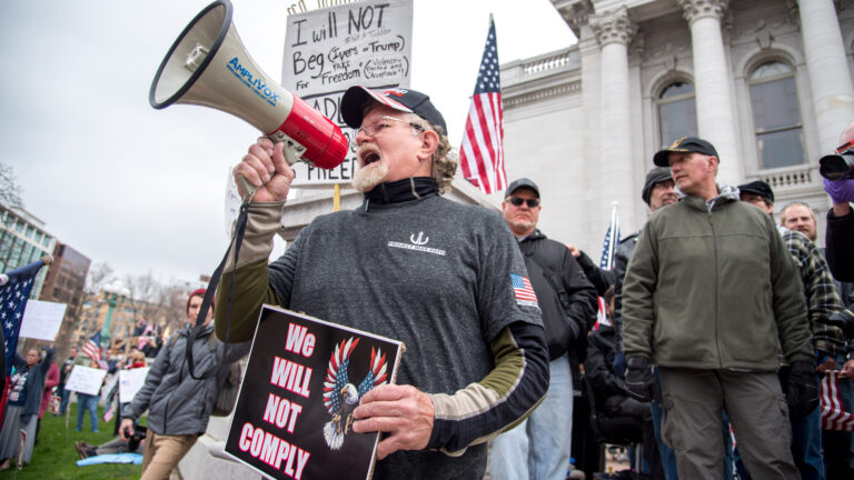 An estimated 1,500 protesters, most of them not wearing face masks and many carrying American flags, gathered at the Wisconsin State Capitol on April 24, 2020 for a 90-minute demonstration demanding an end to the shutdown of public spaces and business in Wisconsin aimed at curbing the coronavirus pandemic. Six months later, Wisconsin has become a national COVID-19 hotspot, with deaths and hospitalizations mounting. Public health experts say mixed messaging from state leaders has harmed efforts to encourage Wisconsinites to wear masks and keep a distance to keep the virus from spreading. (Will Cioci / Wisconsin Watch) An estimated 1,500 protesters, most of them not wearing face masks and many carrying American flags, gathered at the Wisconsin State Capitol on April 24, 2020 for a 90-minute demonstration demanding an end to the shutdown of public spaces and business in Wisconsin aimed at curbing the coronavirus pandemic. Six months later, Wisconsin has become a national COVID-19 hotspot, with deaths and hospitalizations mounting. Public health experts say mixed messaging from state leaders has harmed efforts to encourage Wisconsinites to wear masks and keep a distance to keep the virus from spreading. (Will Cioci / Wisconsin Watch)