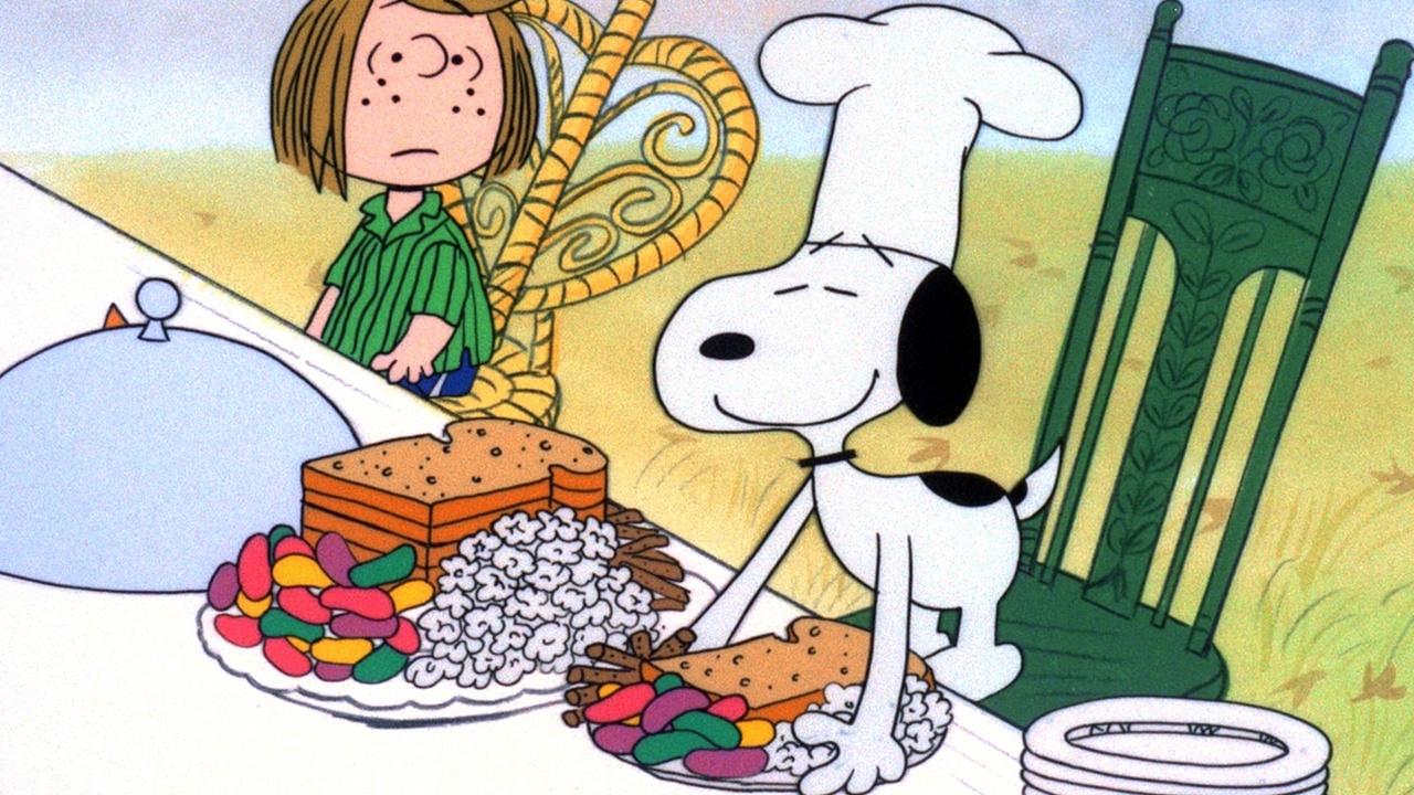 Illustration of Snoopy the dog leaning over a Thanksgiving feast