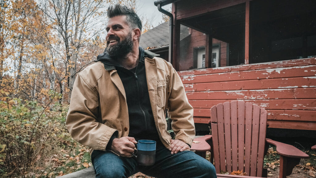 Wisconsin Foodie host Luke Zahm sits in front of a read porch on an autumn day
