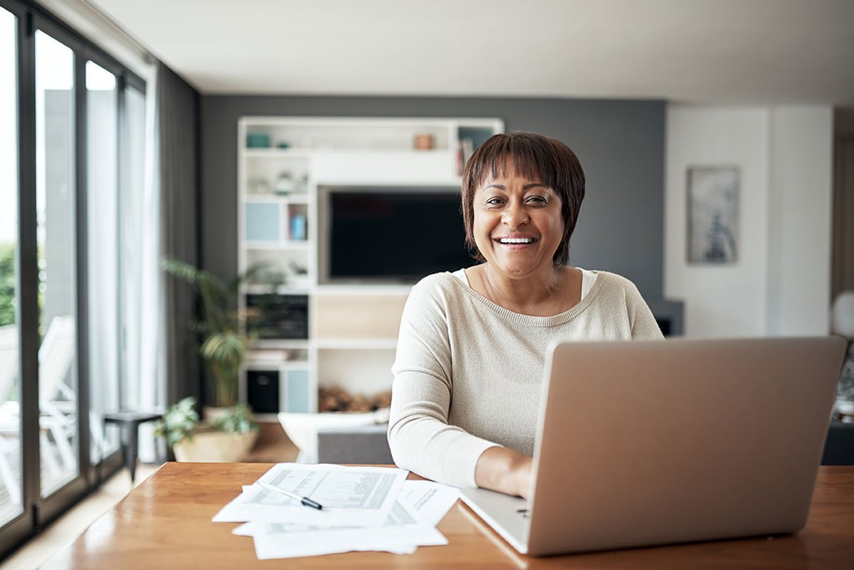 Woman on Laptop with Documents