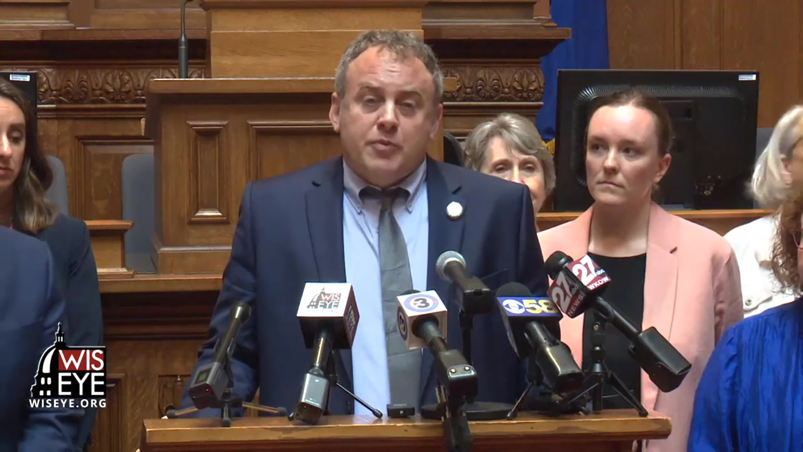 Screenshot of state Rep. Gordon Hintz speaking into microphones in Wisconsin Assembly chambers, surrounded by other Democrats.