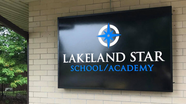 A sign for Lakeland STAR School/Academy on an exterior brick wall