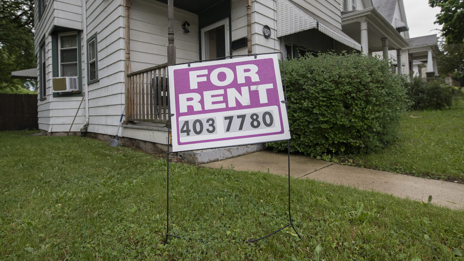 A For Rent sign in front the porch and entrance to a house