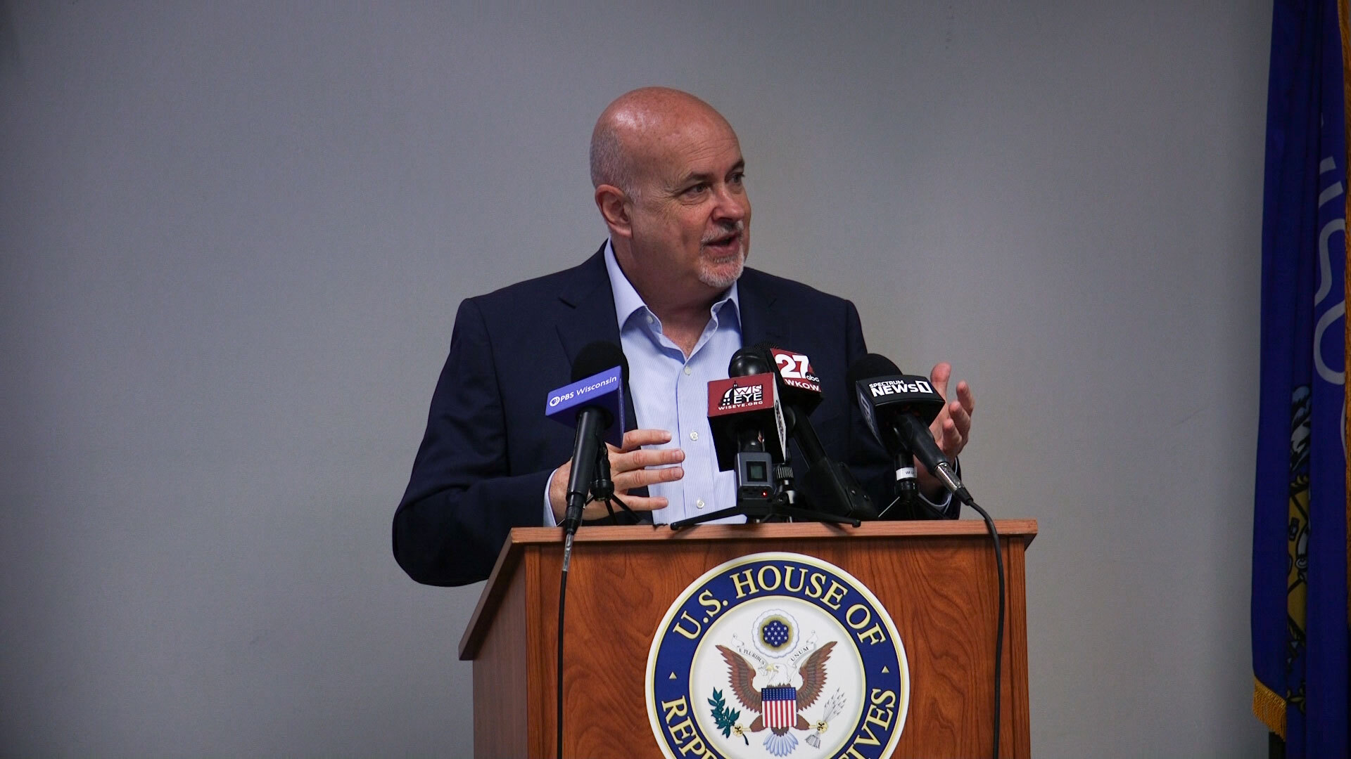 Mark Pocan speaks at a podium with a U.S. House of Representatives seal.
