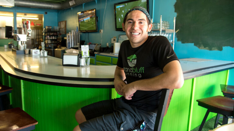 Donald Greengrass Jr. sits on a chair at a restaurant counter