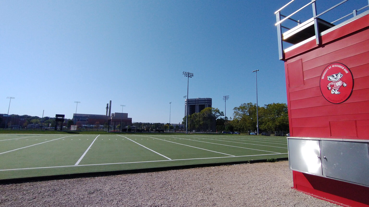 A red conductor's podium overlooks the green turf of the UW Marching Band's practice field on the UW-Madison campus.