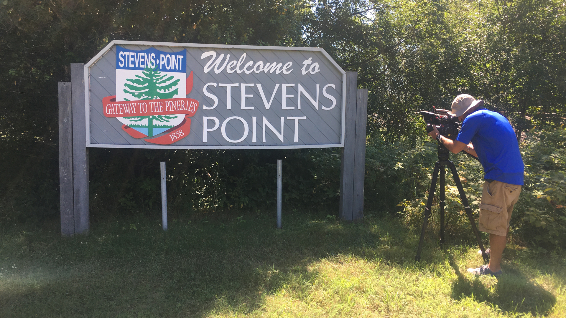 A camera man films a welcome sign to Stevens Point, Wisconsin