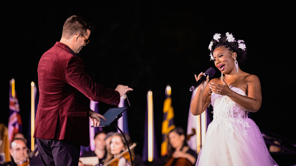 An opera singer and conductor on stage.