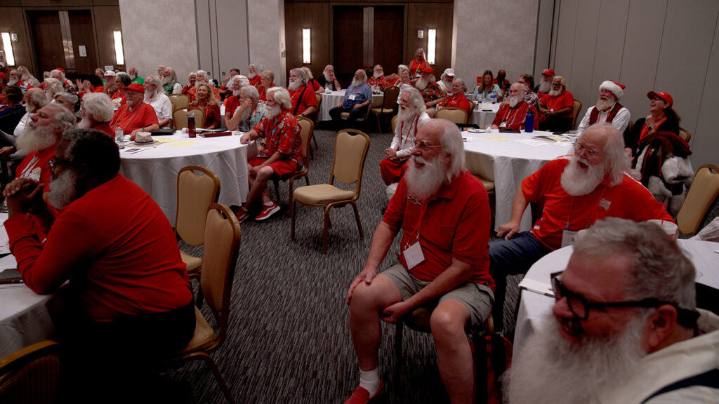 A room full of men who look like Santa Claus with white beards and hair.