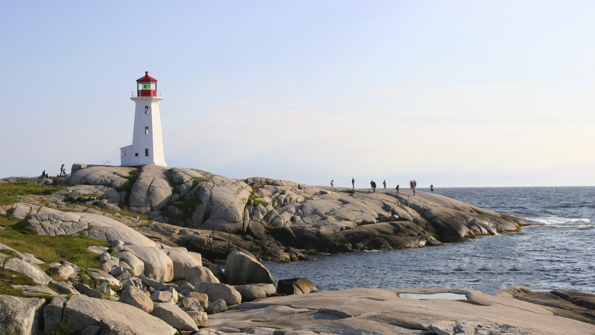 A lighthouse stands on a rocky shore