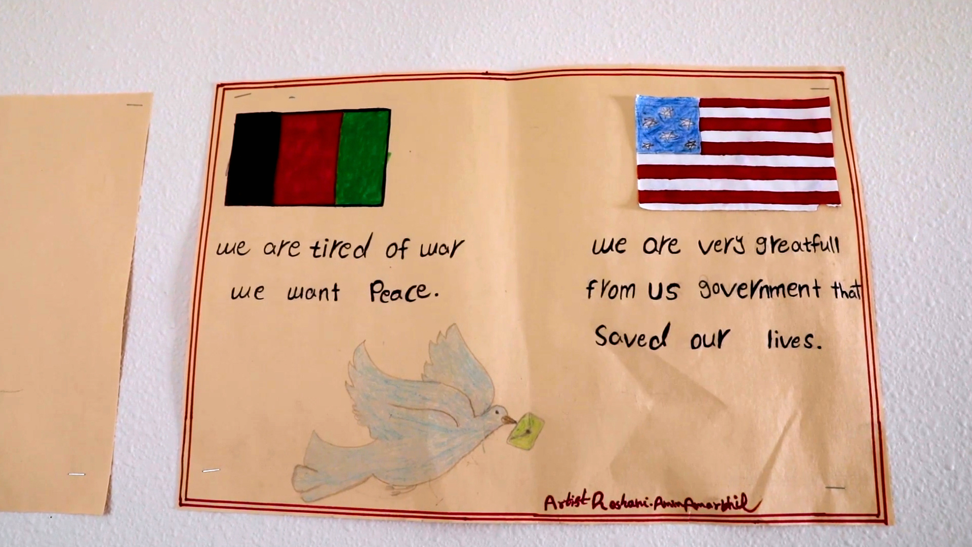 A hand-drawn poster shows an Afghan flag with the legend "we are tired of war, we want peace" and an American flag with the legend "we are very greatfull from US government that saved our lives."