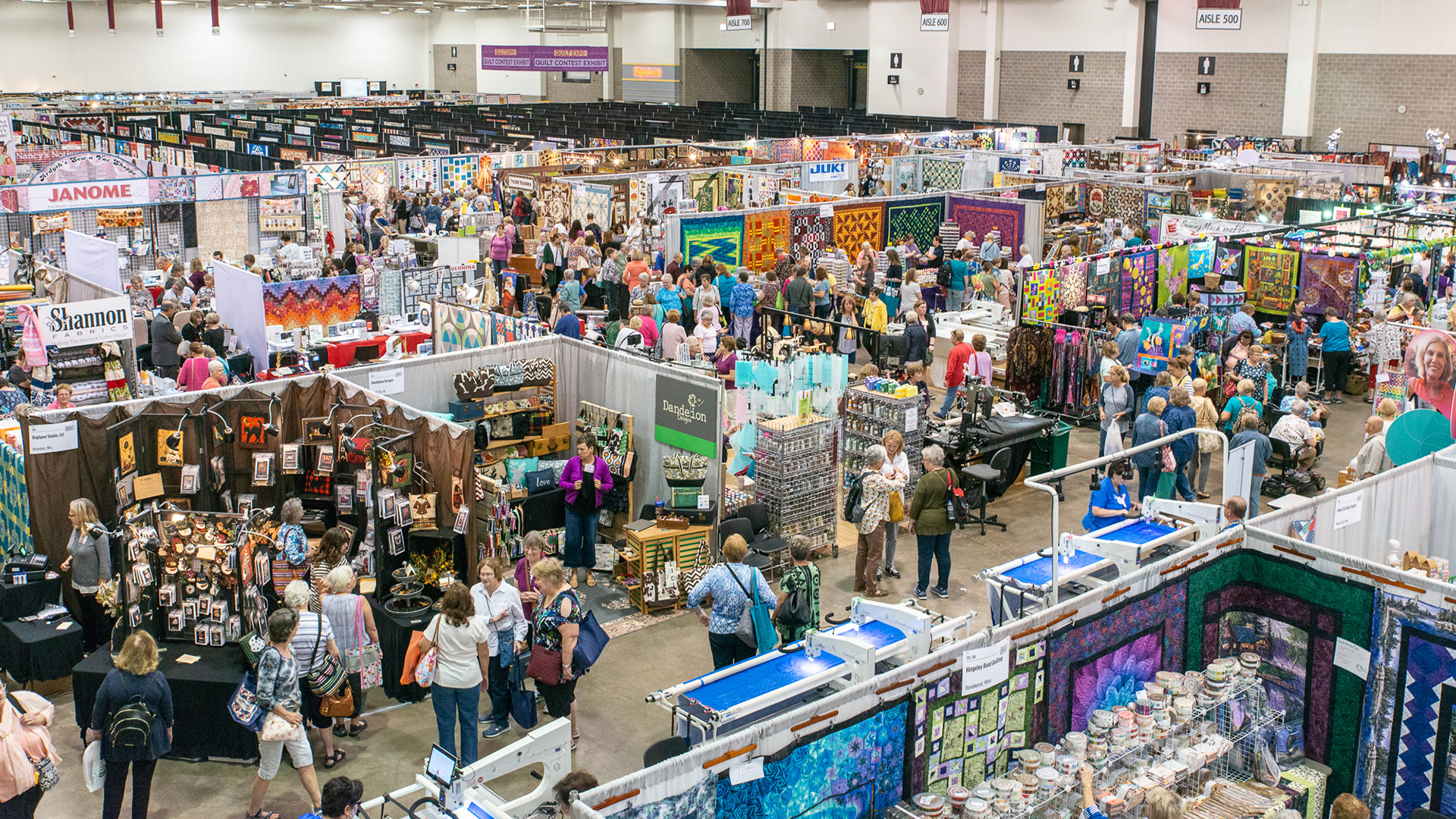 An overhead view of the event floor filled with quit show vendor booths and crowds of visitors