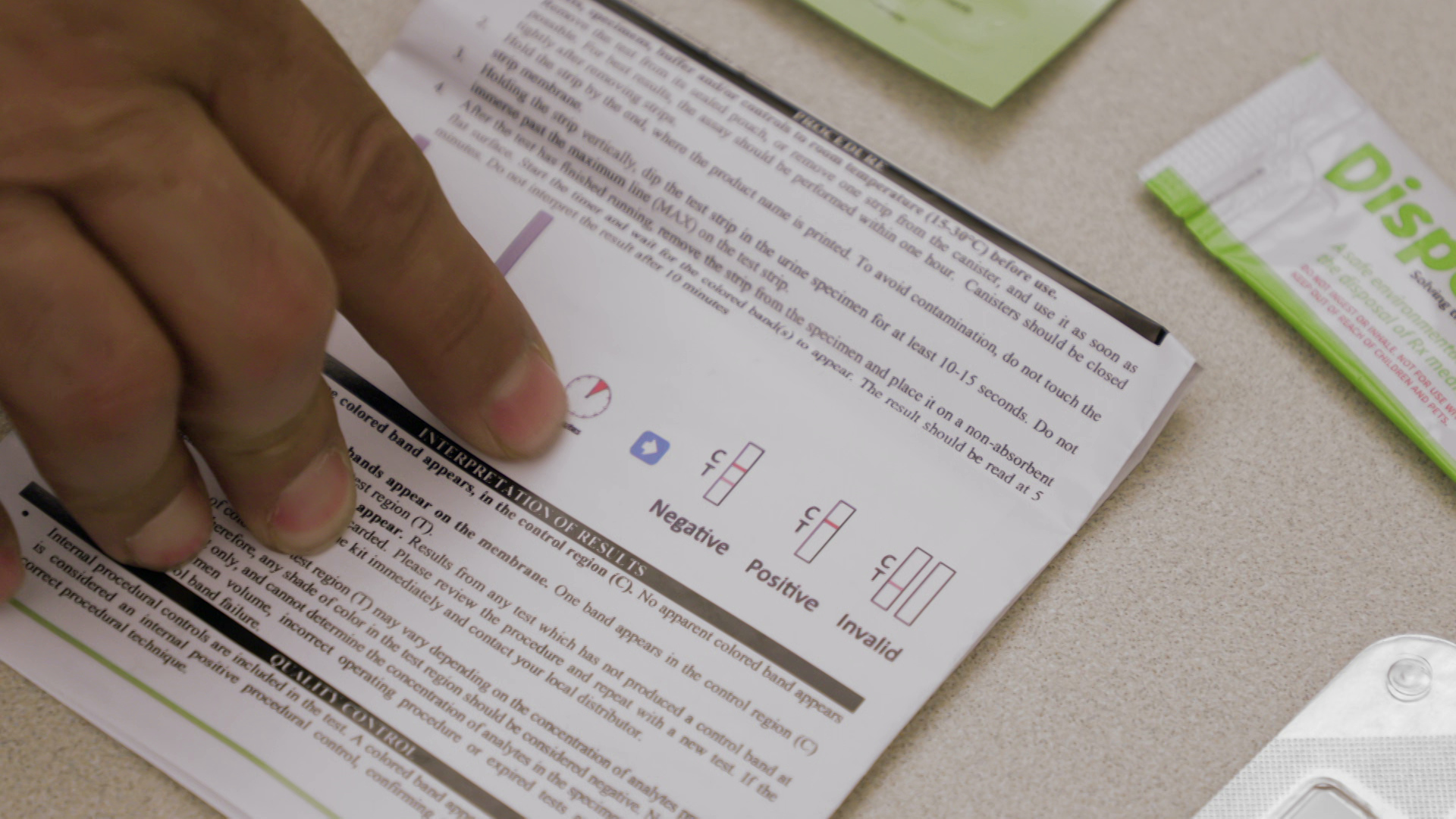 An index finger points toward instructions for a fentanyl testing strip.