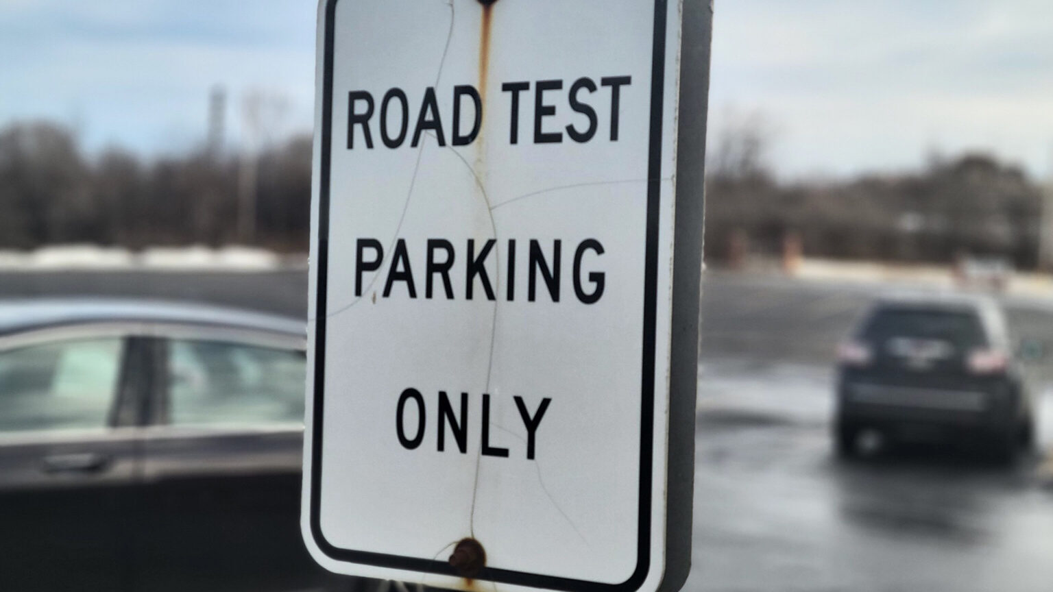 A sign in a parking lot reads Road Test Parking Only.