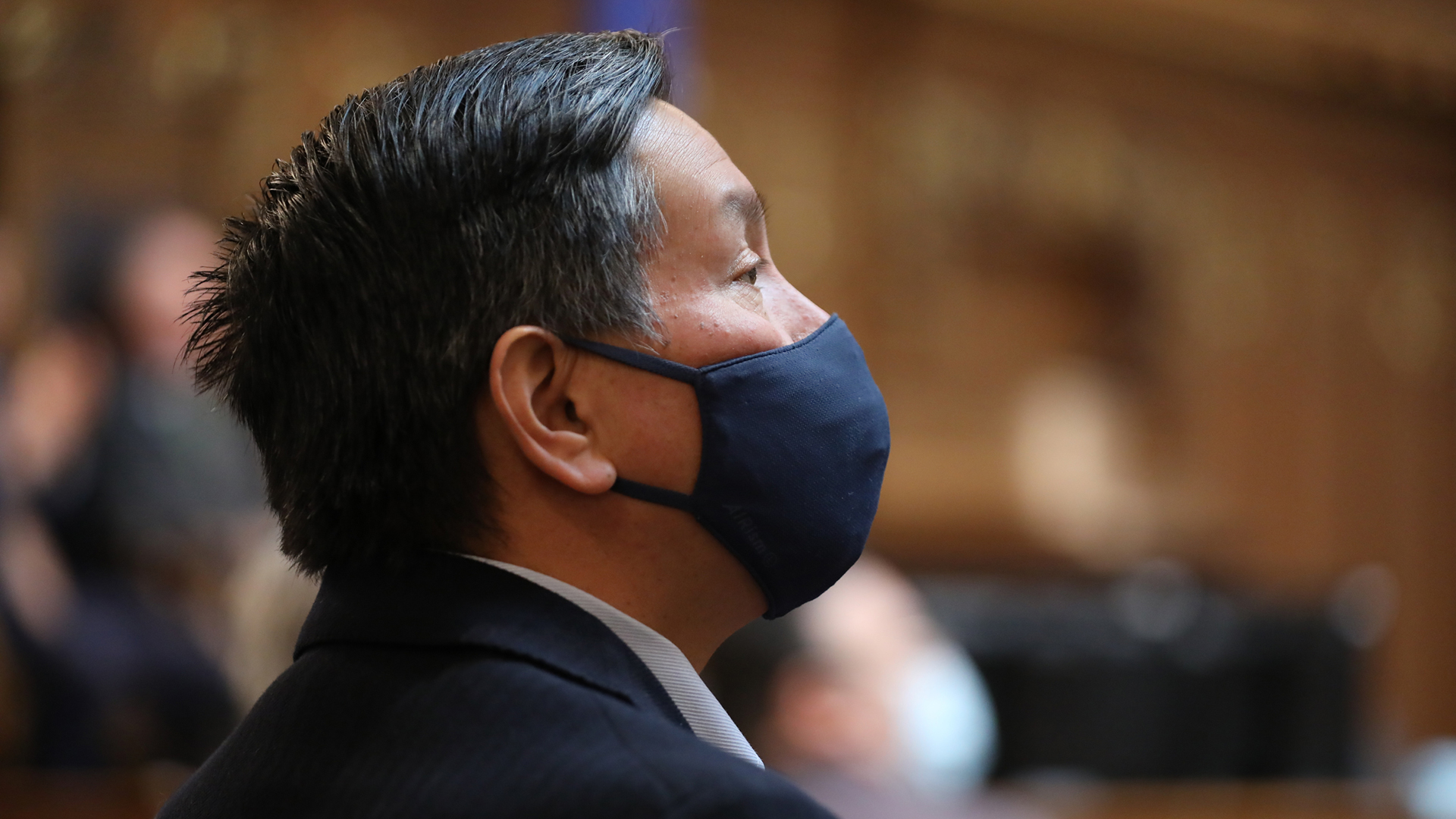 Marlon WhiteEagle wears a face mask while listening to a speaker in the Wisconsin Capitol.