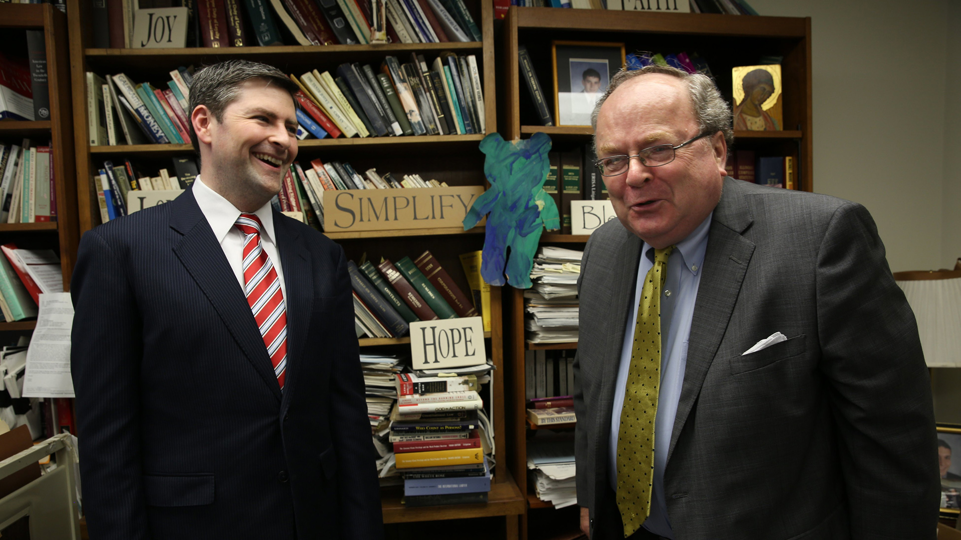 Peter Breen and Thomas Brejcha stand in a room with bookshelves in the background.