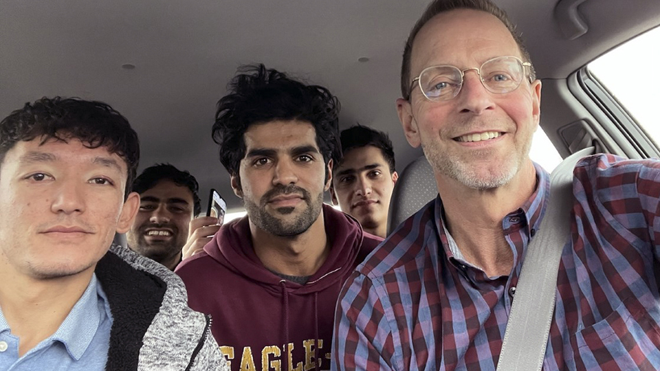 Ali Akbar Gholami, Muddassir Saboory, Ahmad Samim Samimi, Fayaz Nabizada and Mike Ruminski pose for a selfie inside a car.