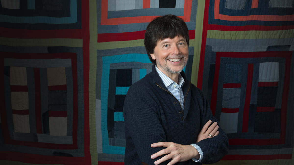Ken Burns standing in front of a colorful quilt