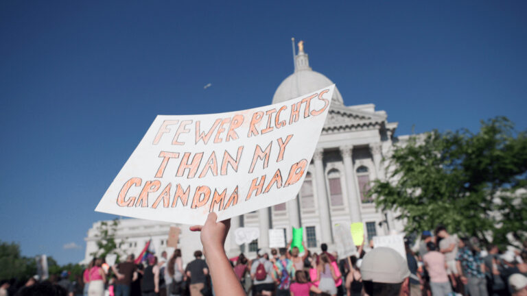 A sign reading Fewer rights than my grandma had is held up at a rally in front of the Wisconsin Capitol.