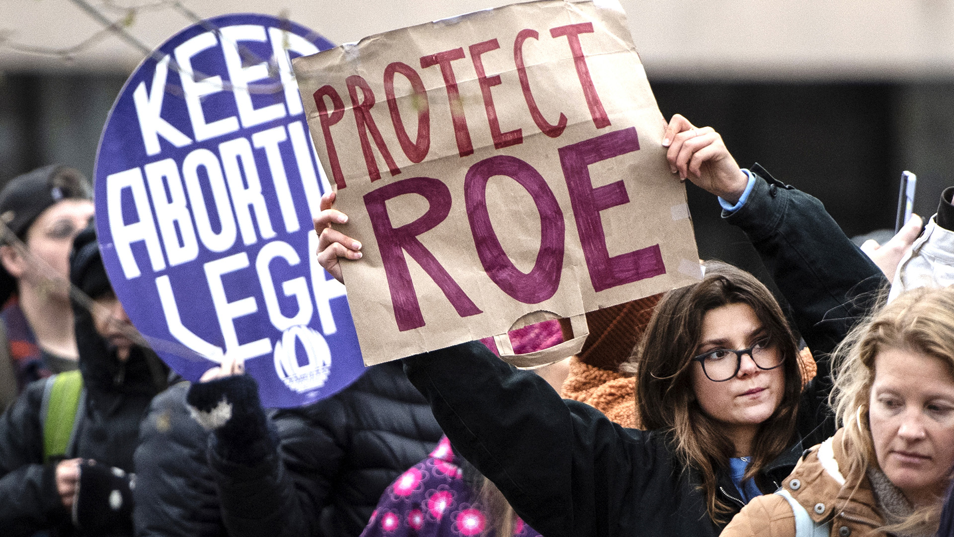 Protestors hold signs that read "Keep Abortion Legal" and "Protect Roe."