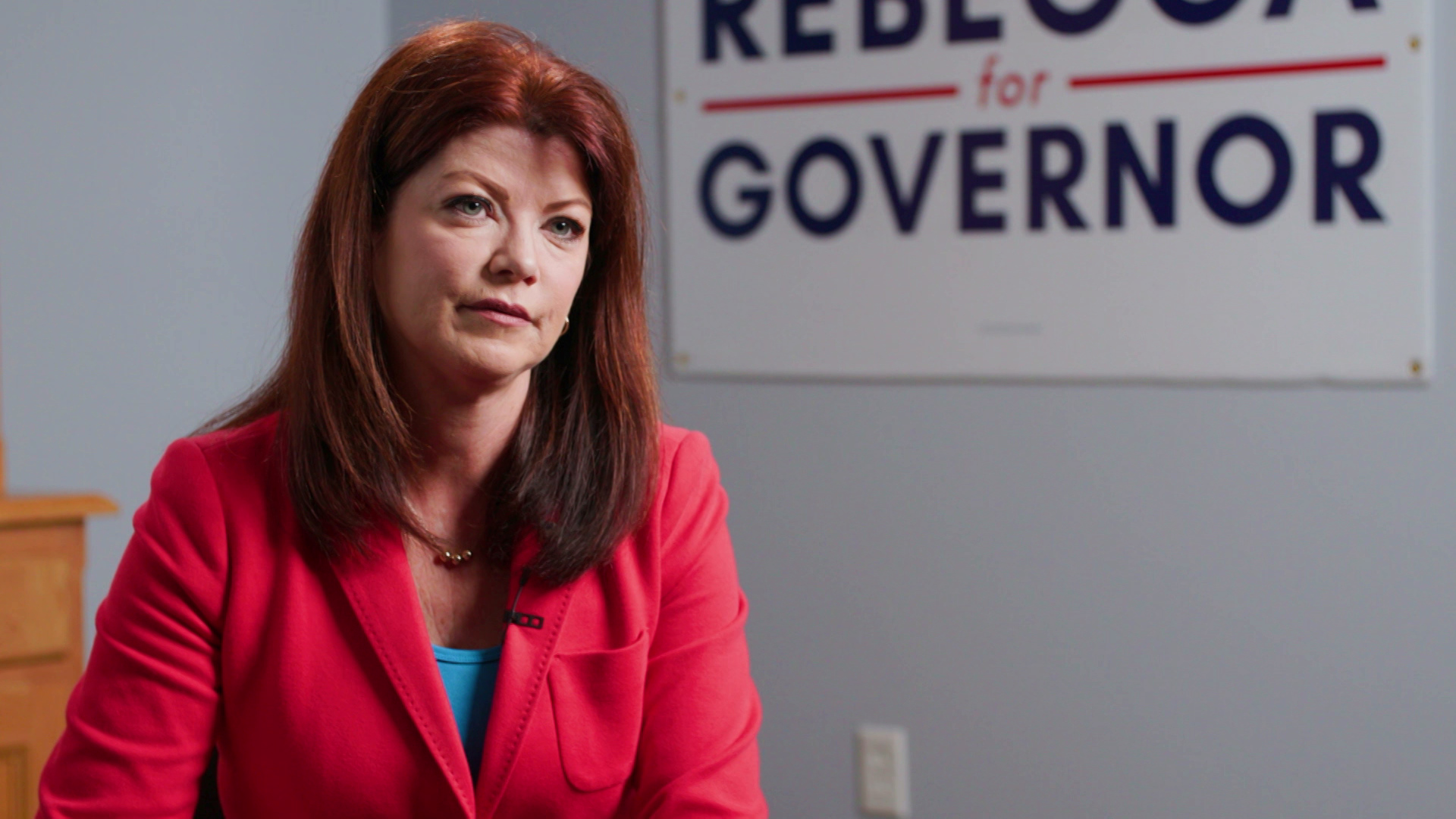 Rebecca Kleefisch is seated in a room with a sign reading "Rebecca for Governor" in the background.