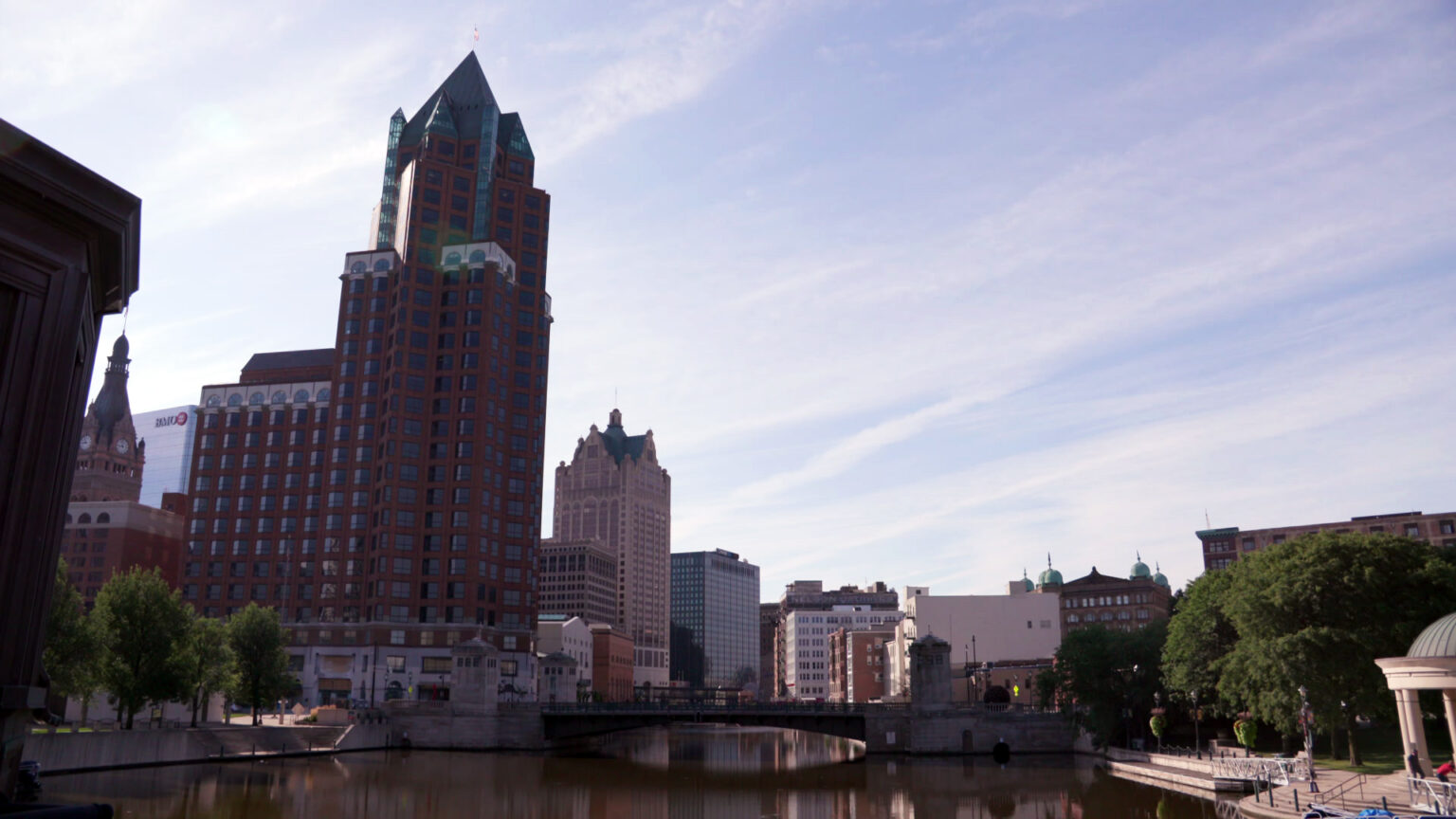 Skyscrapers and other buildings line the east and west shores of the Milwaukee River as it flows through the city's downtown.