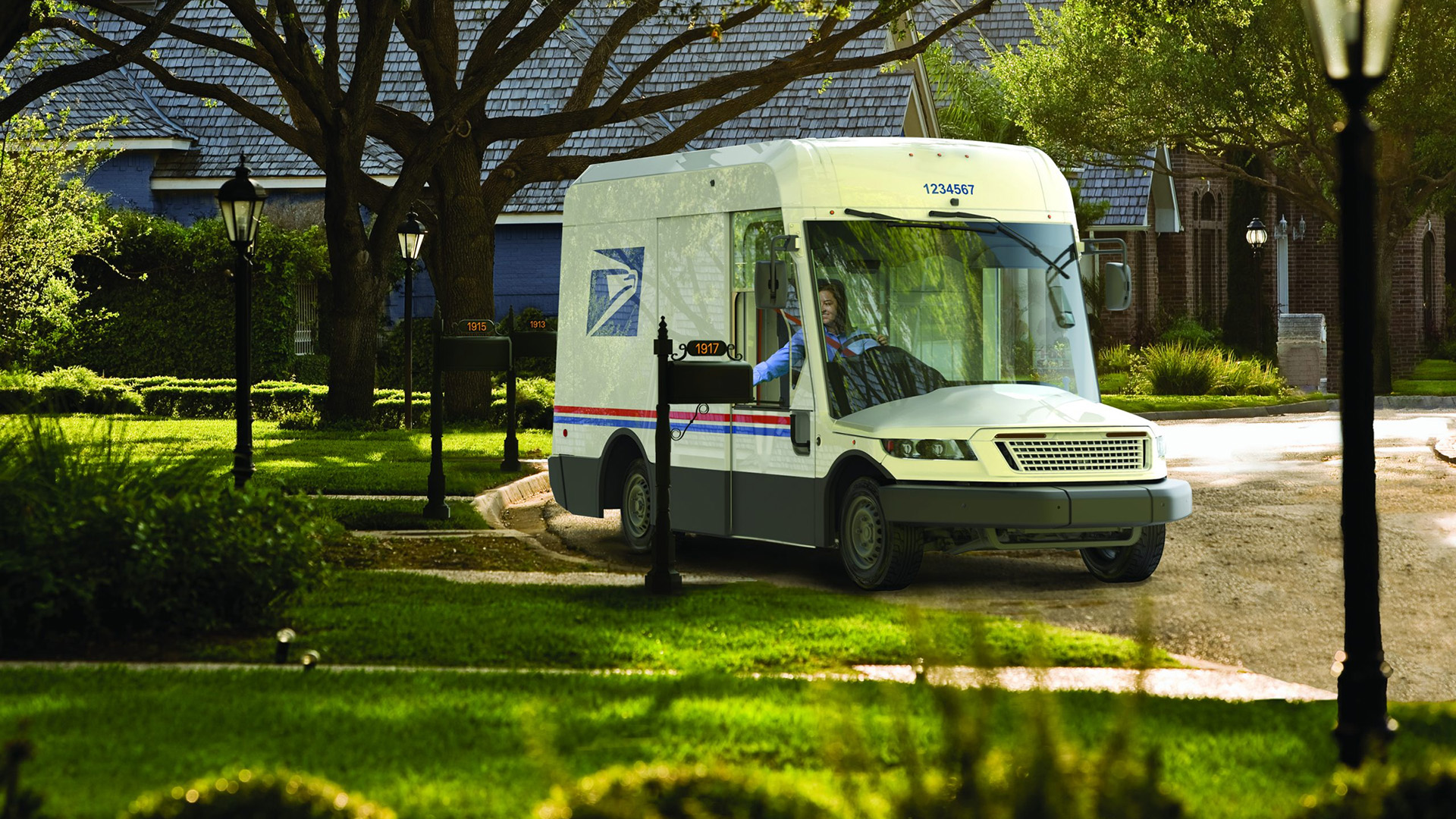 An illustration shows a design for a U.S. Postal Service delivery truck on a street scape with mail boxes, street lights, trees and houses.