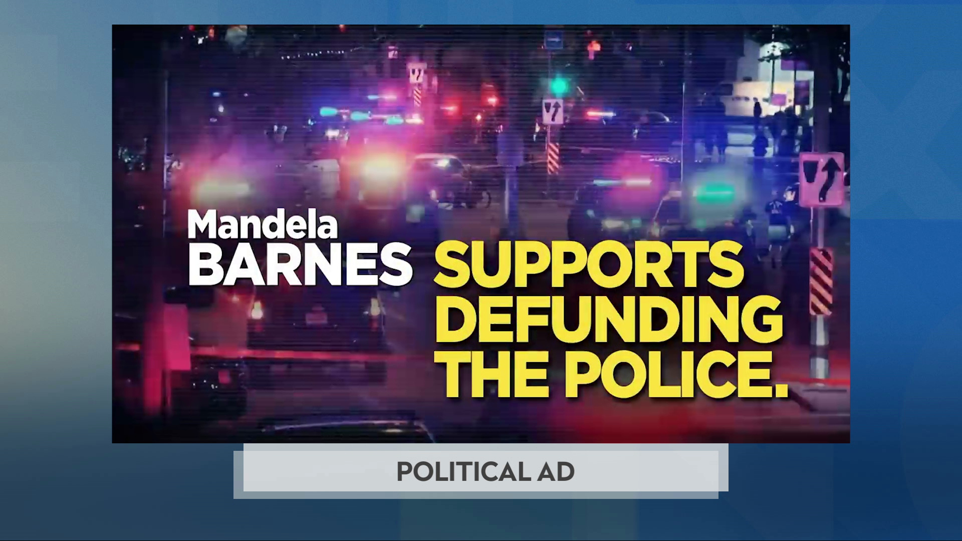A still image from a political advertisement shows a nighttime scene of numerous police vehicles in an area surrounded by crime scene tape with the words "Mandela Barnes Supports Defunding The Police."
