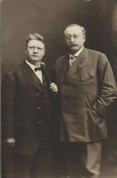 A historical sepia-toned photo shows Emil Seidel and Victor Berger posing for a portrait.