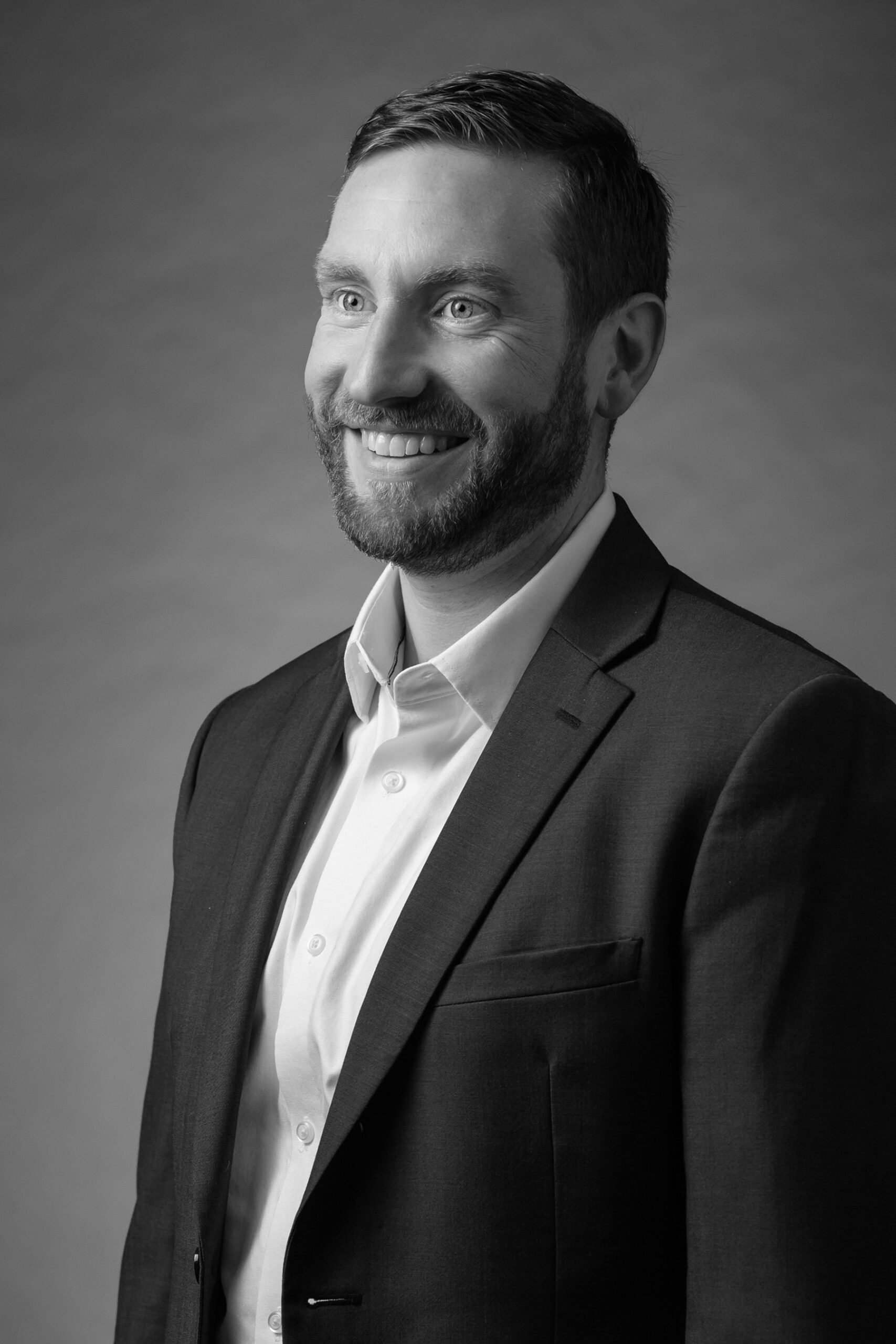 Black and white portrait of Director of Individual Giving, Travis Lamensky