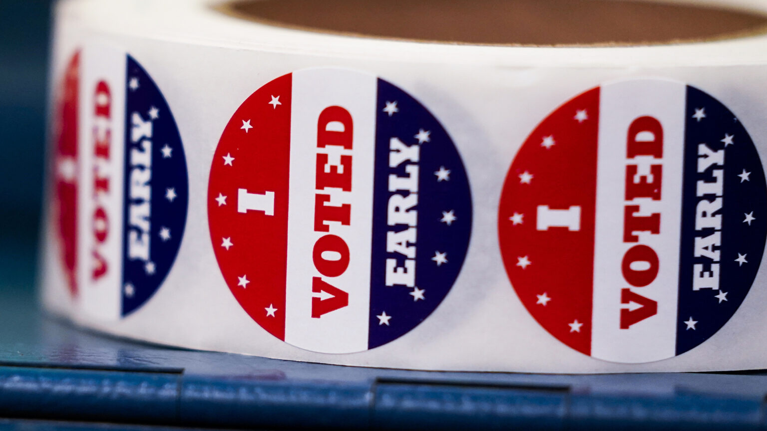 Stickers that read I Voted Early with a red, white and blue design sits on a flat surface.