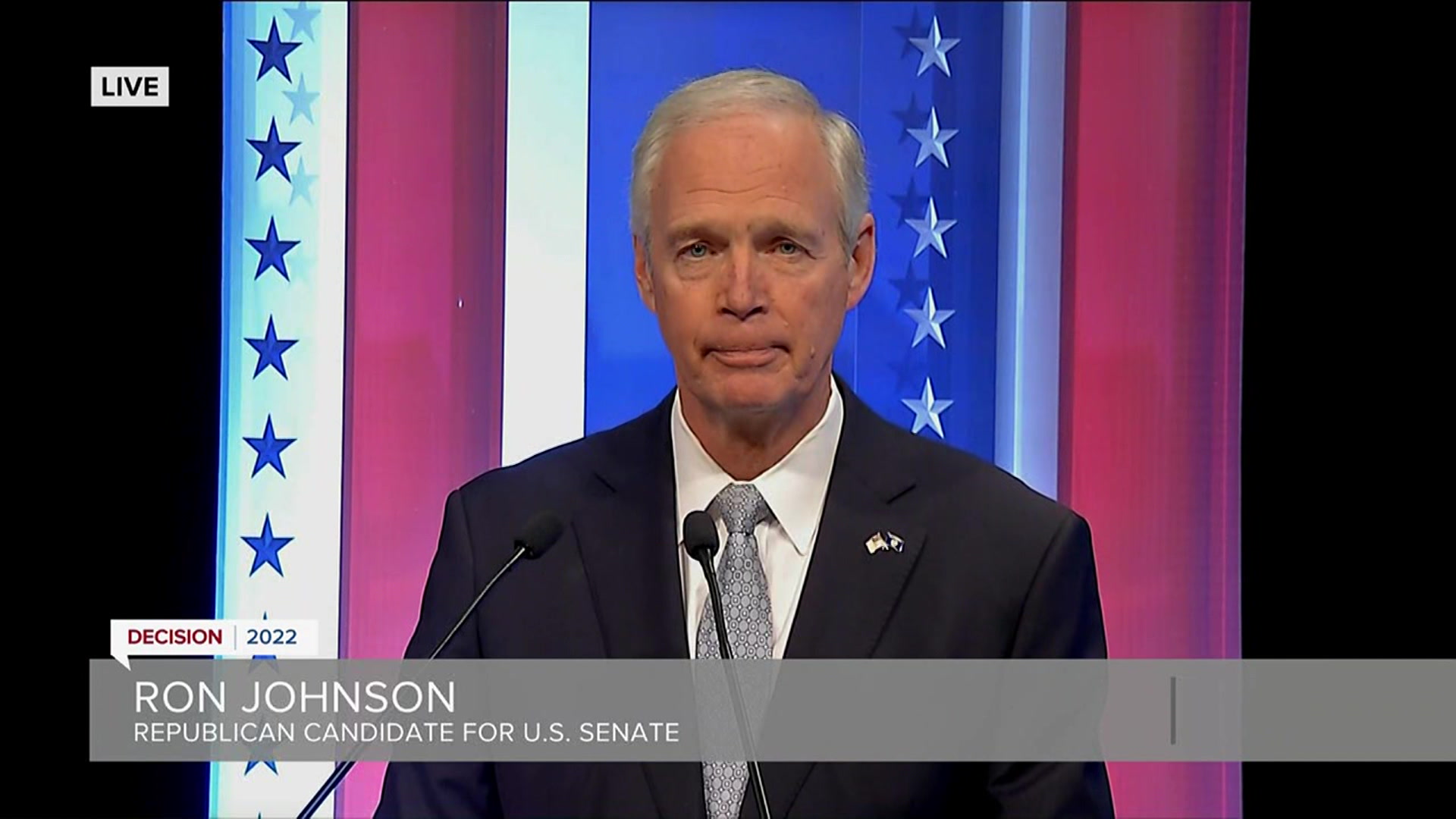 Ron Johnson faces a camera during a televised debate.