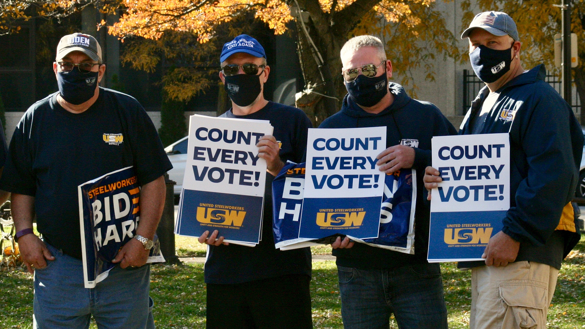 Four members of United Steelworkers stand outside while holding signs reading "Steelworkers for Biden Harris" and "Count Every Vote!"