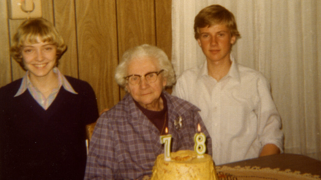 A 70's era family photo of Susan Apps-Bodilly with Eleanor and Jeff Apps sitting at a table with a birthday cake
