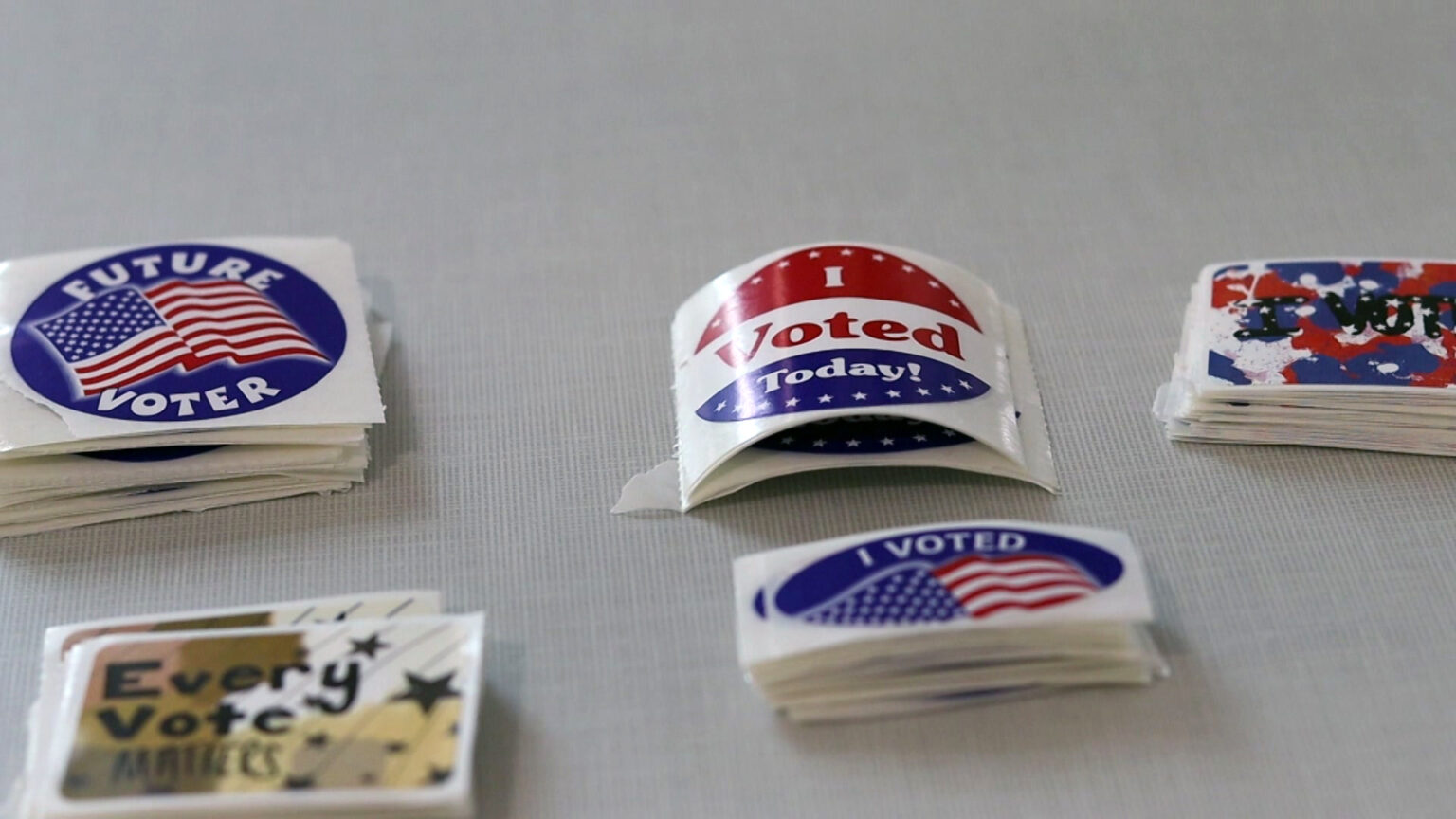 Several stacks of stickers sit on a table, with graphics and slogans that read I Voted Today! I Voted, Every Vote Matters and Future Voter.