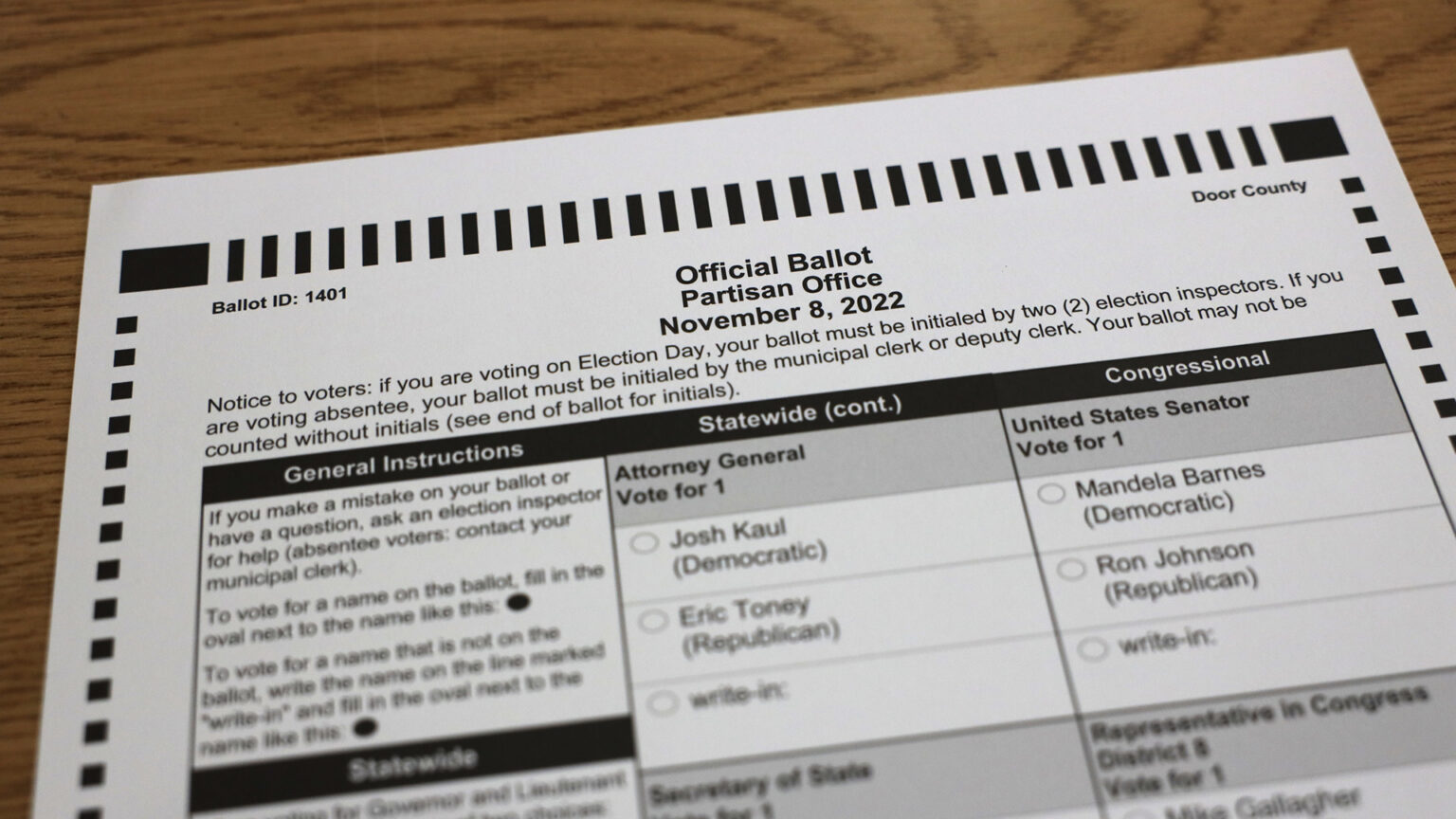 A ballot with the header text Official Ballot, Partisan Office and November 8, 2022 sits on the surface of a wood table.