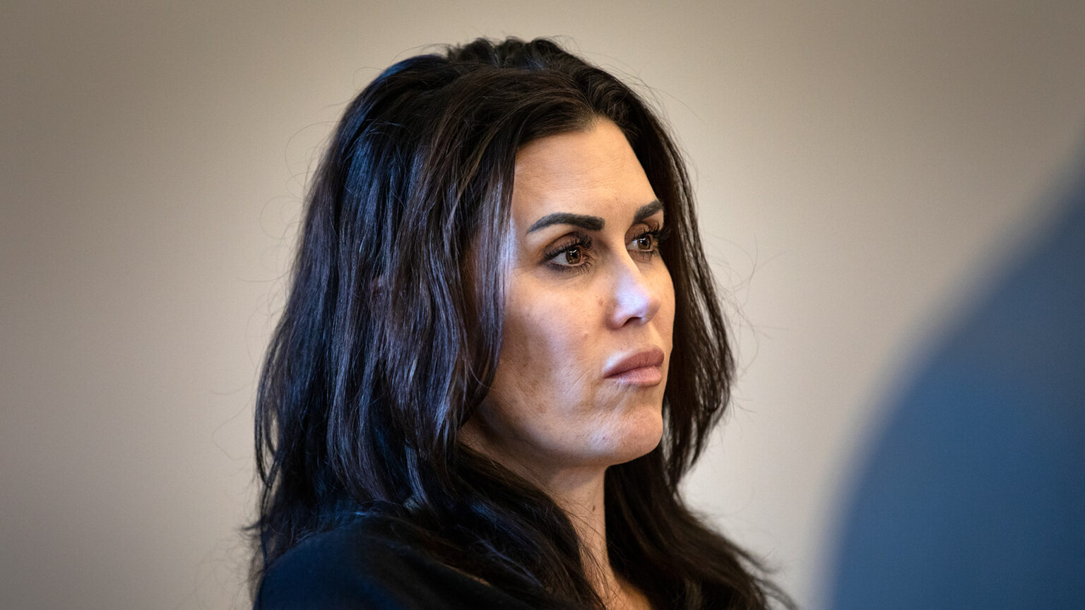 Jennifer Dorow sits and listens to another person speaking in a meeting.