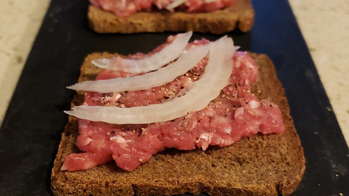 A "cannibal sandwich" consisting of raw beef, raw onion, salt and pepper on rye bread.