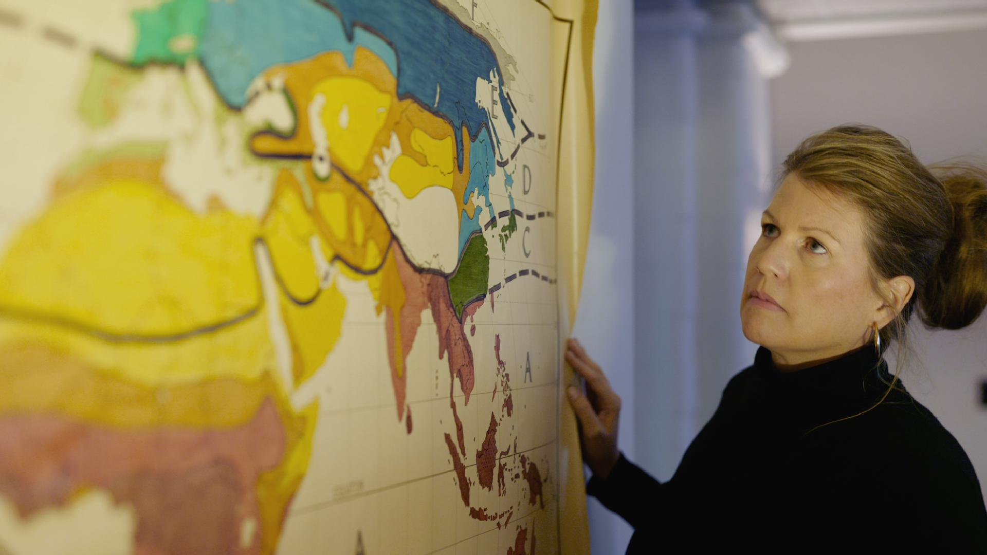 A woman looks at a map on the wall