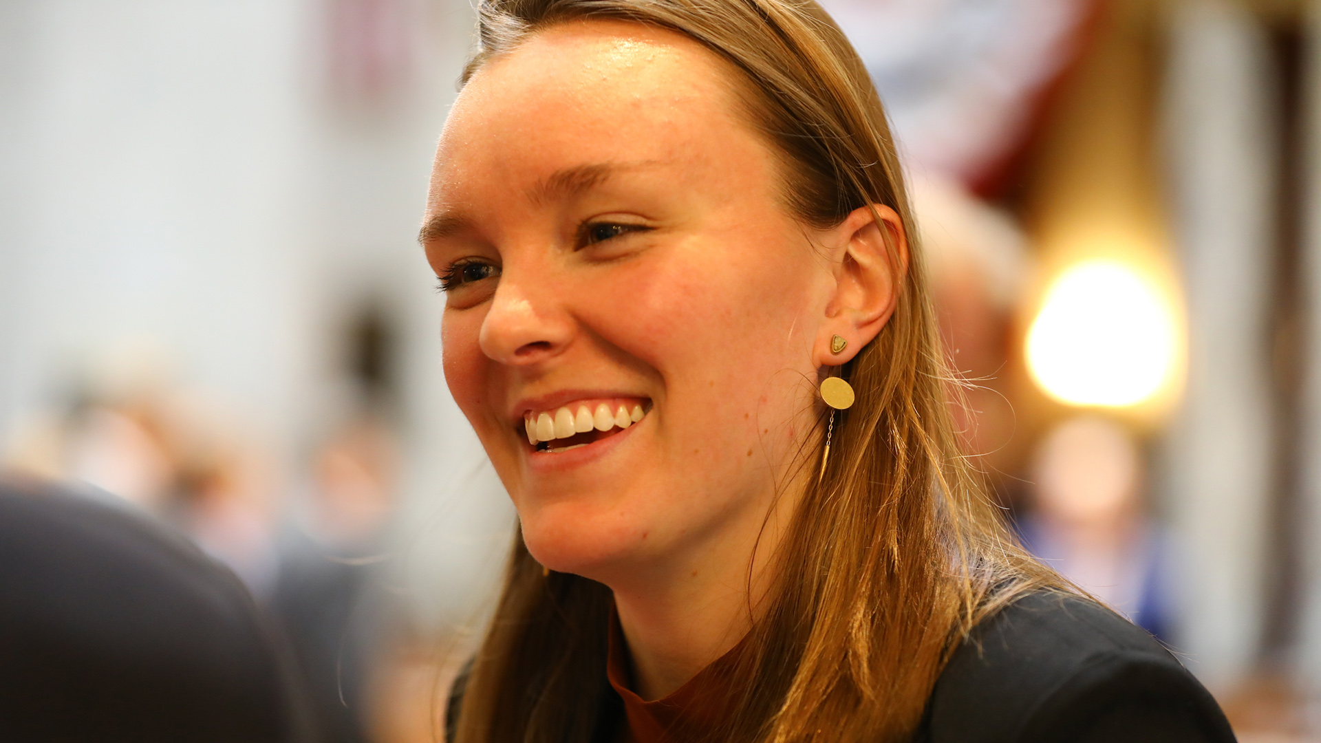 Greta Neubauer smiles while speaking to another person.