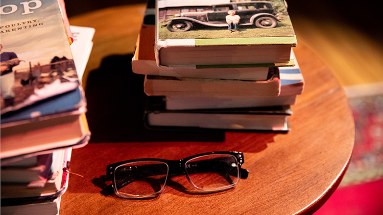 Michael Perry's table with books and reading glasses on them from a live performance at the Stoughton Opera House.
