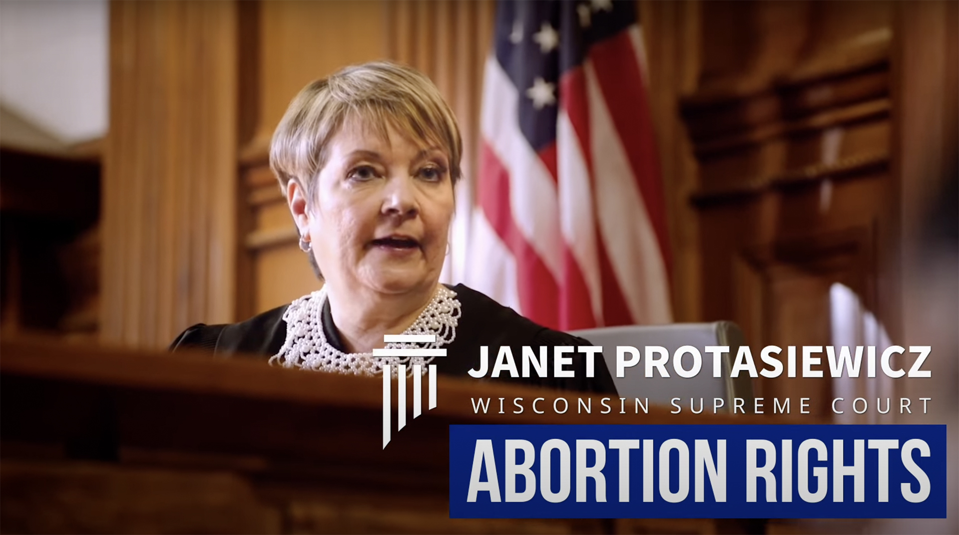 A still image from a video shows Janet Protasiewicz sitting at a judicial dais with the words "Janet Protasiewicz," "Wisconsin Supreme Court" and "Abortion Rights."