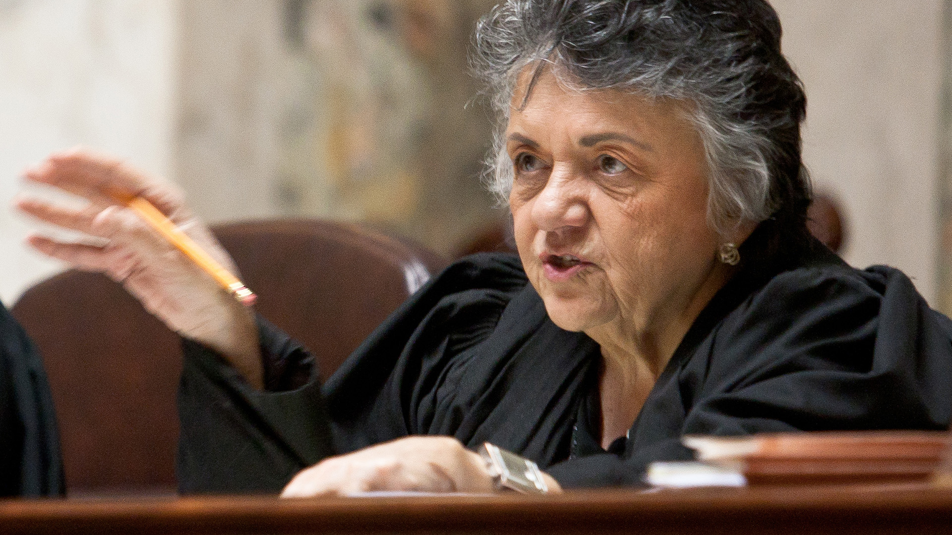 Shirley Abrahamson sits at a dais and speaks while gesturing with her right hand.