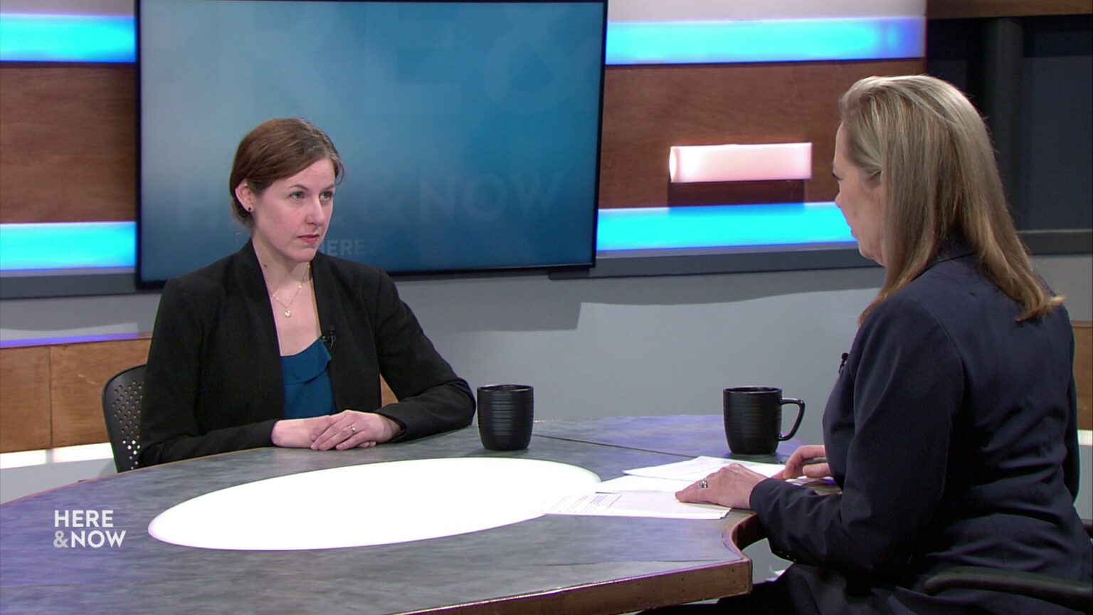 Cecelia Klingele and Frederica Freyberg sit facing each other on the Here & Now set.