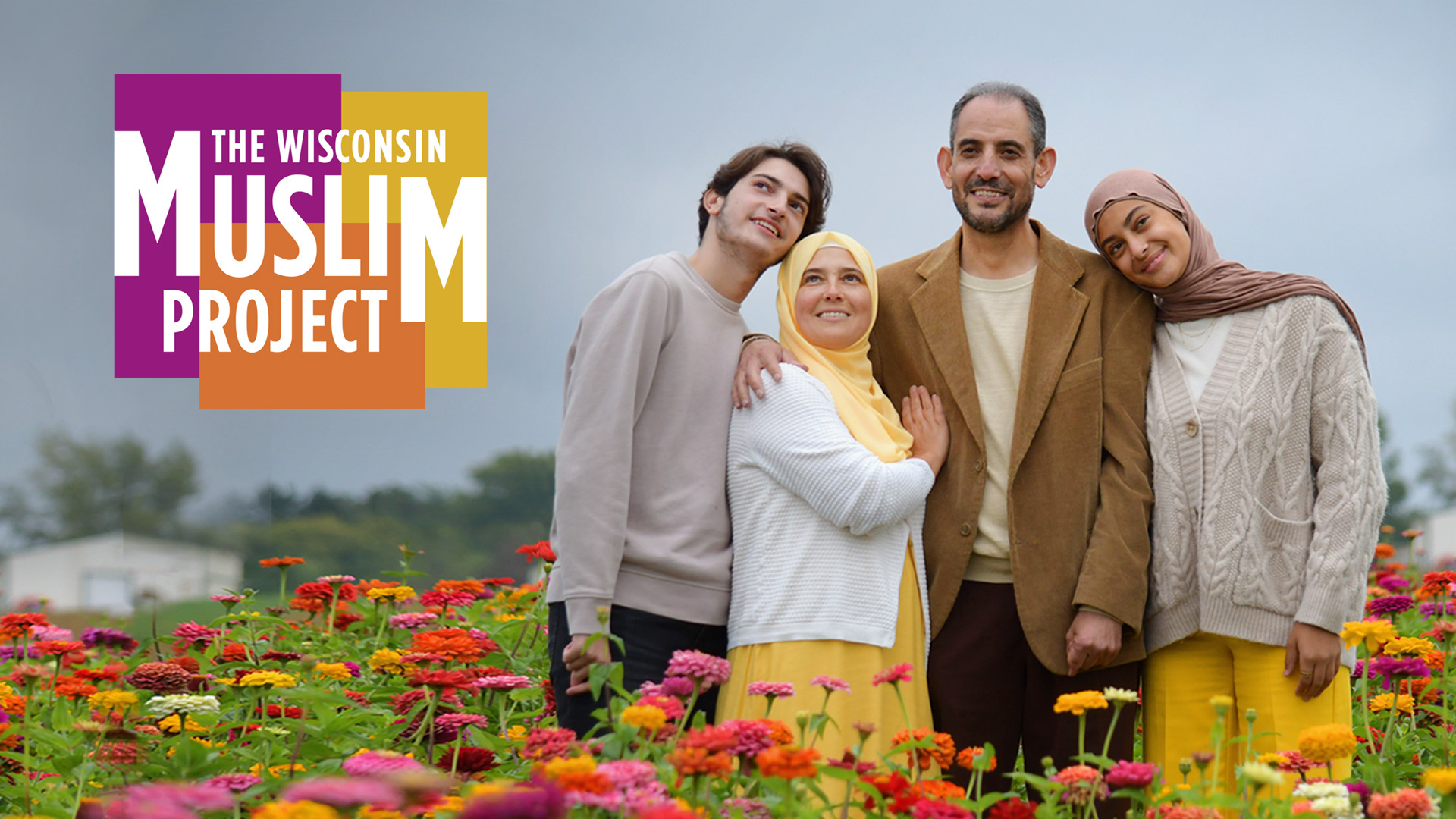 Muslim family standing in a field of flowers.